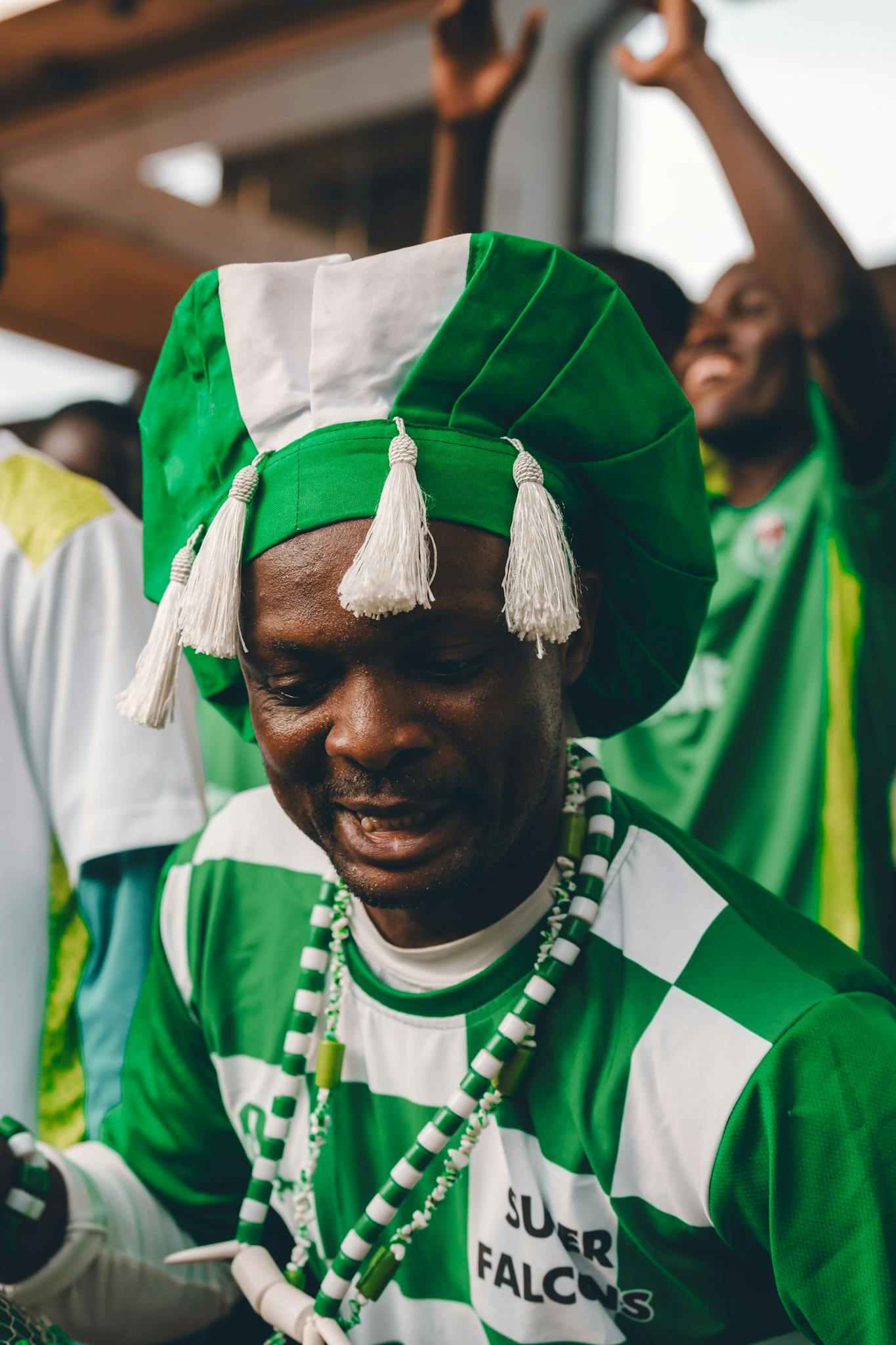 Man in traditional green attire celebrates at a Nigerian event, showcasing cultural pride and vibrancy.