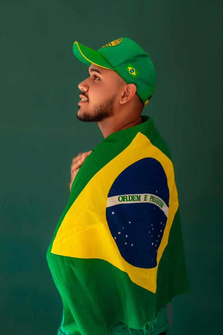 Portrait of a Brazilian football fan wrapped in the national flag, displaying pride and patriotism.